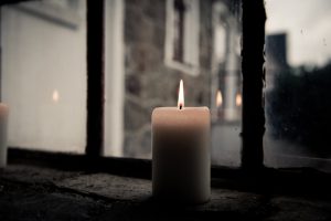 A candle is lit in front of the window.