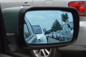 A rear view mirror of cars on the road