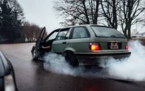 A car that is smoking on the road.